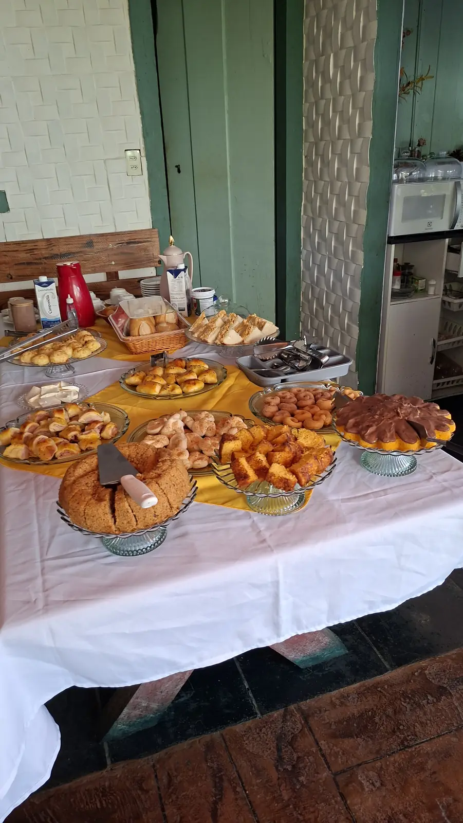 Mesa do café da manhã com bolos, quitandas e bebidas