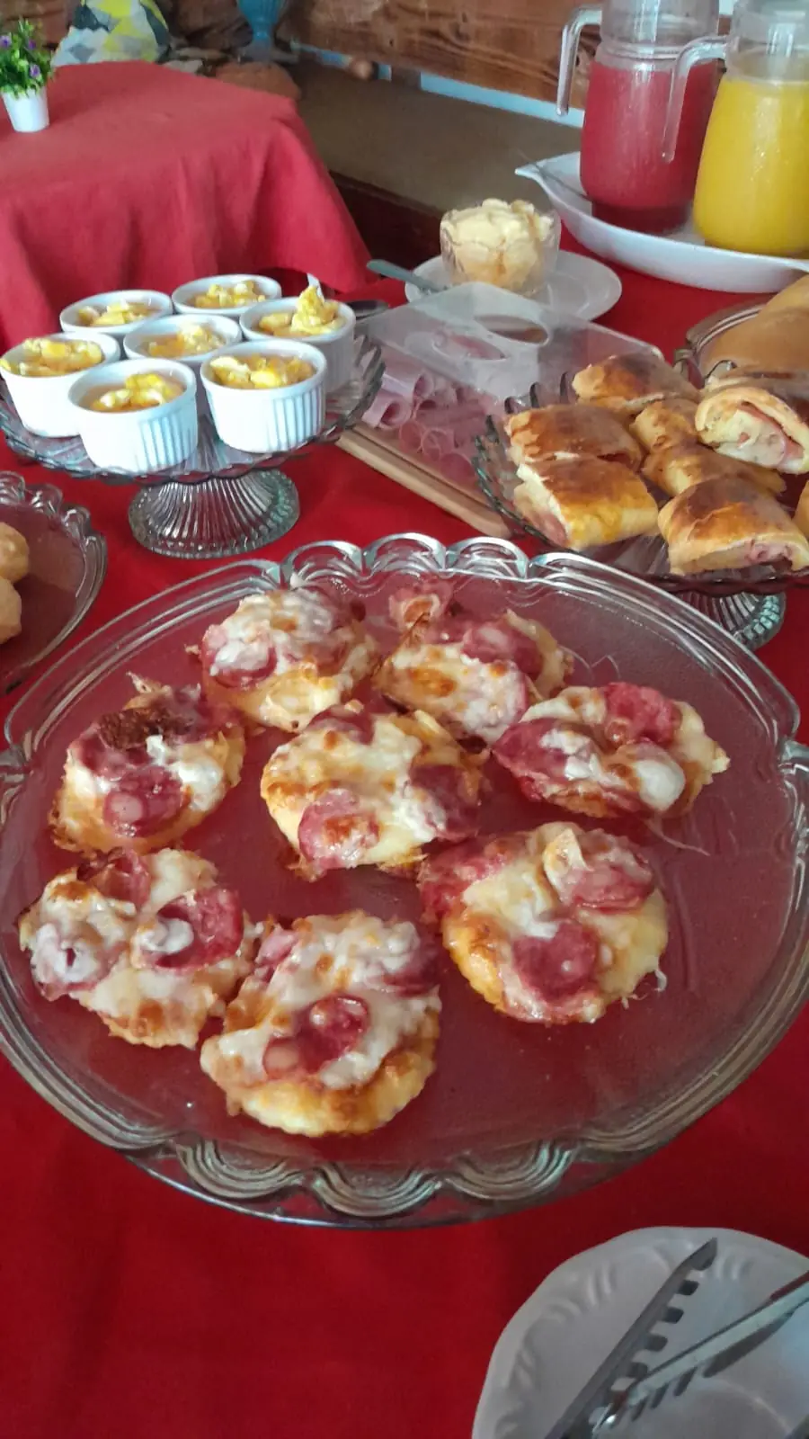 Quitutes assados e jarras de suco na mesa do café