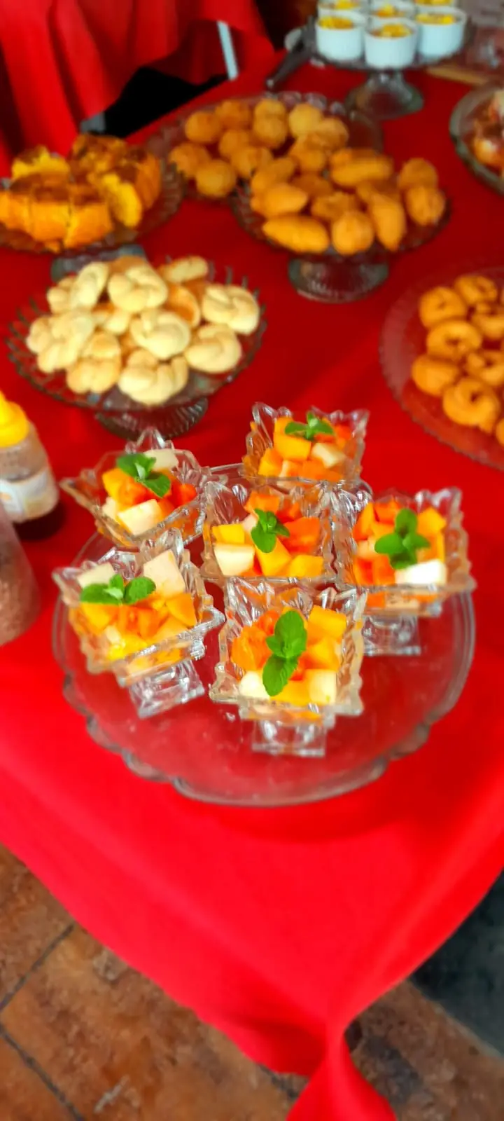 Taças de salada de frutas e quitandas na mesa do café